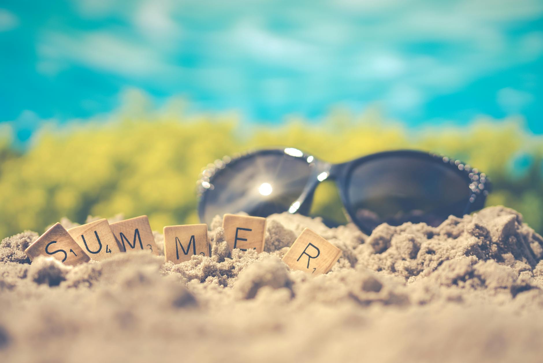 macro photography of black sunglasses on sand